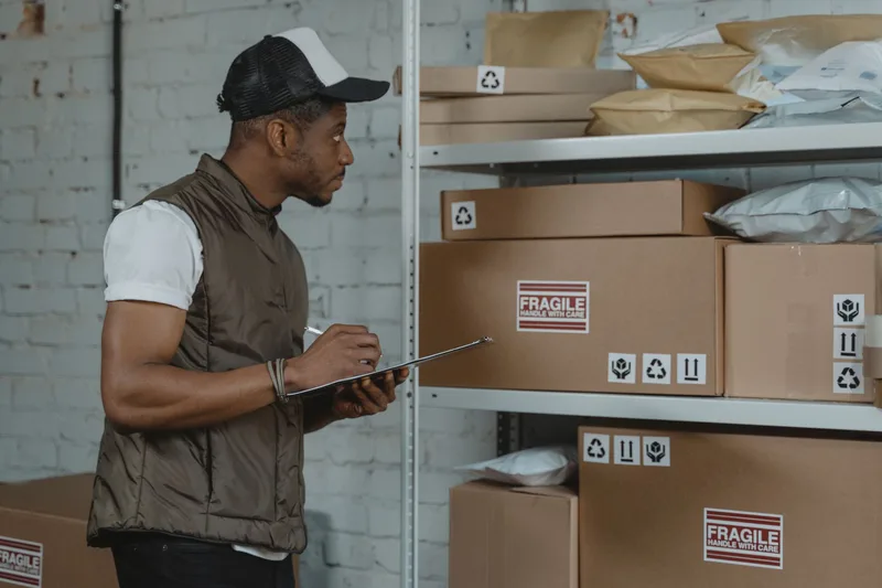 Warehouse staff member checking a shipping label against a package before dispatch