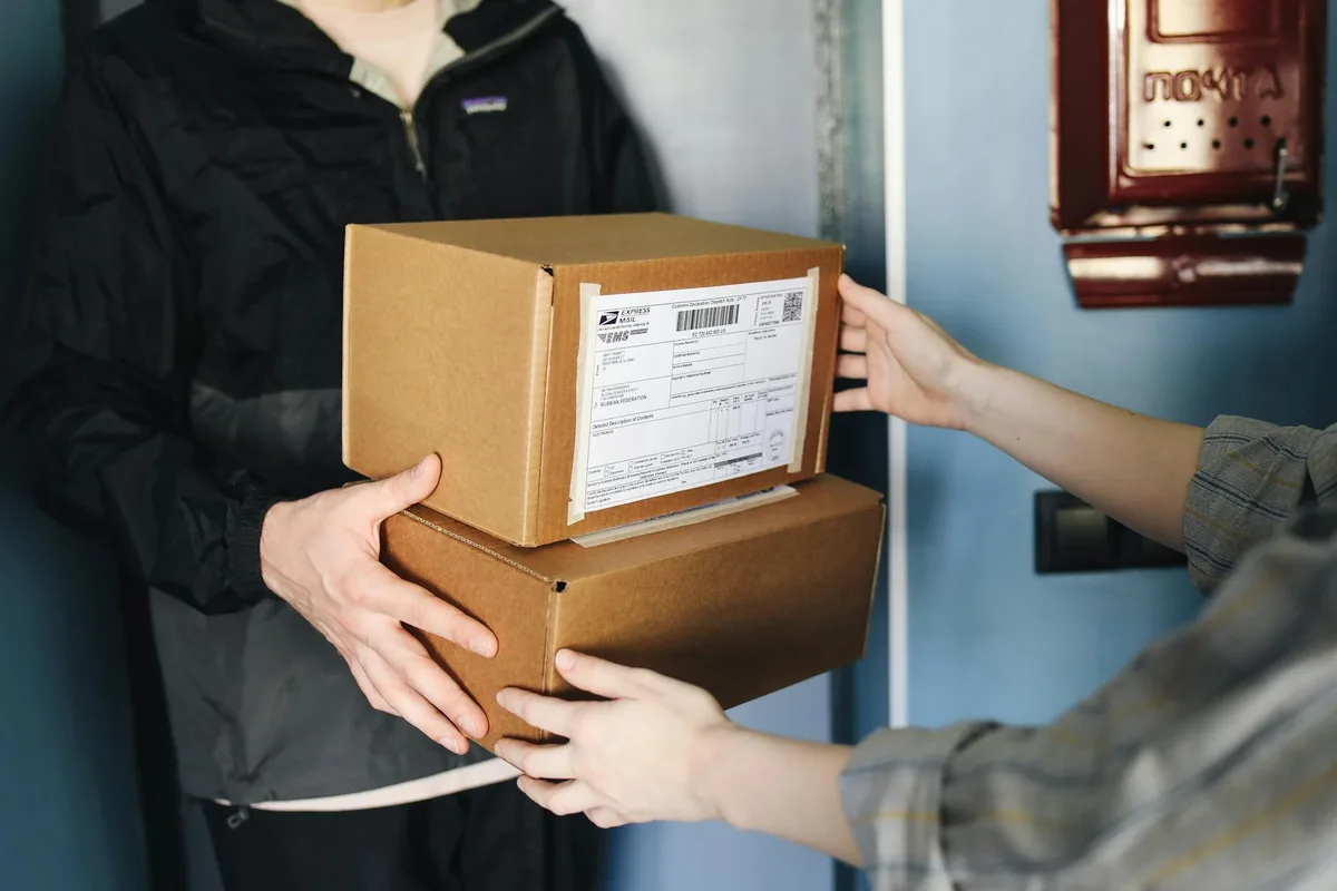 Ecommerce packaging materials laid out on a table including poly mailers, cardboard boxes, bubble wrap, and kraft paper rolls
