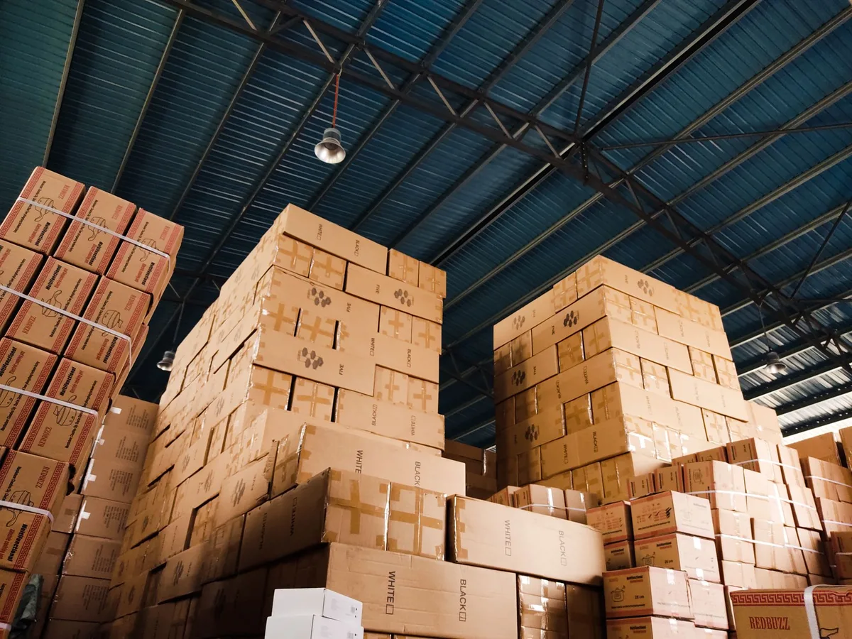 Kotak-kotak dibungkus dan disusun di gudang ecommerce, sedia untuk penghantaran kurier