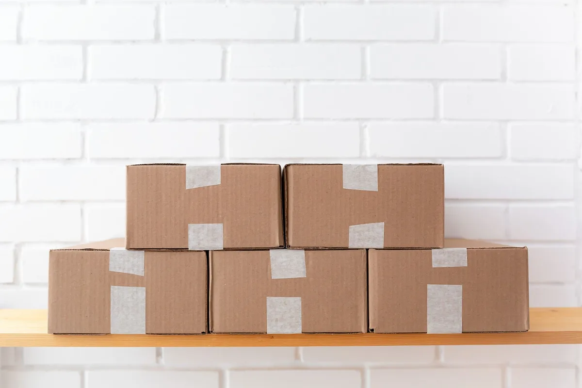 Kotak-kotak ecommerce disusun di gudang, sedia untuk dihantar oleh kurier