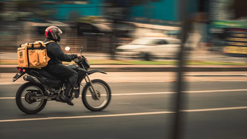 Kurier atas motosikal menghantar bungkusan melalui jalan bandar