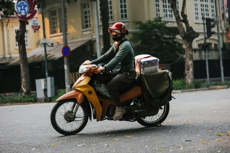 Kurier atas motosikal menghantar bungkusan di kawasan bandar
