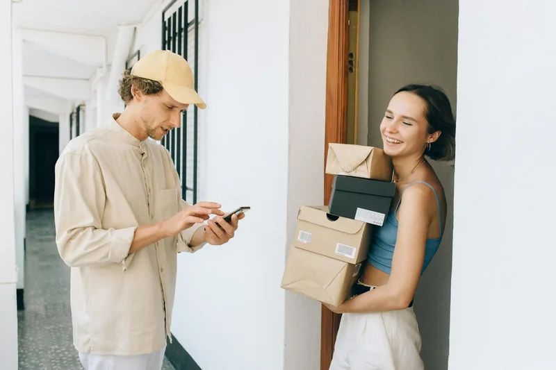 Cash on delivery payment exchanged at a Malaysian residential doorstep, courier handing receipt to buyer